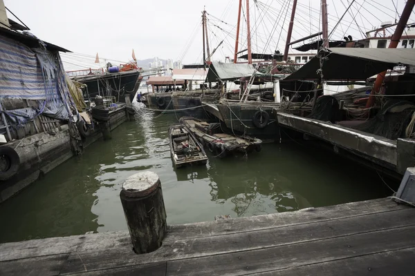 Fishing boats are at the wooden pier in the port of Macau. — Stock Photo, Image