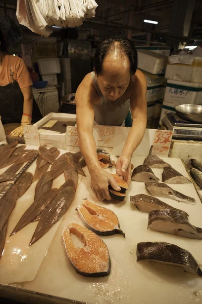 Fishmonger ставит филе рыбы на прилавок Рыбный рынок в — стоковое фото