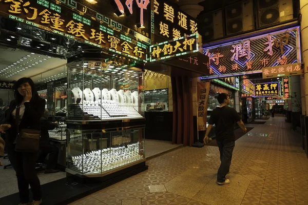 Магазины продают золотые украшения и часы вечером в Макао — стоковое фото