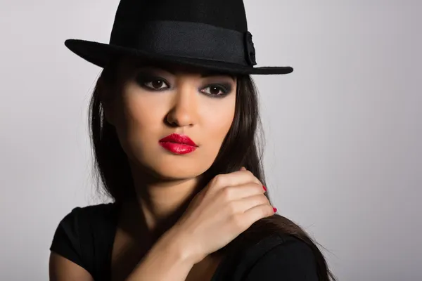 Beautiful Asian girl in a black hat — Stock Photo, Image
