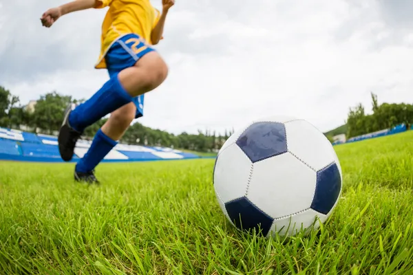 Garçon joueur de football frappe le ballon — Photo