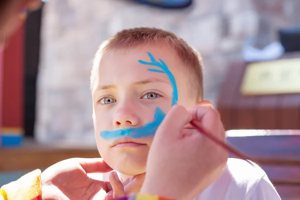 Мальчик рисует лицо акулой — стоковое фото