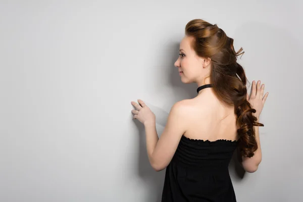 Woman standing face to the wall — Stock Photo, Image