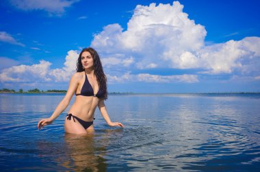 Красивая девушка в воде на озере.