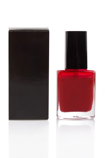 Red nail polish bottle and black packaging — Stock Photo, Image