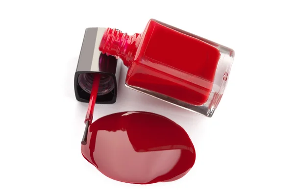 Red nail polish bottle with spilled varnish isolated on white ba — Stock Photo, Image