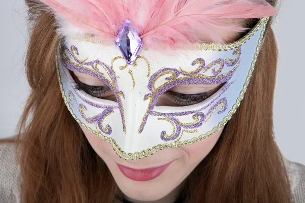 Beautiful teenage girl wearing carnival mask with pink feathers — Stock Photo, Image