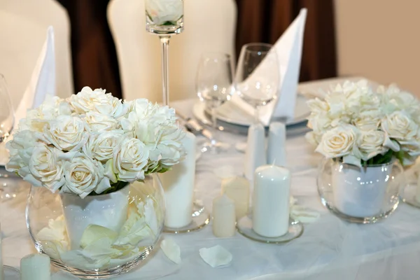 Mesa decorada com velas e rosas brancas — Fotografia de Stock