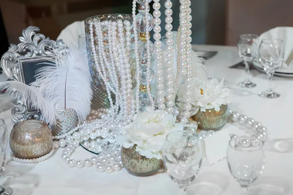 Стол украшен перьями, жемчугом и свечами — стоковое фото