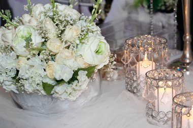 Mumlar, ortanca ve beyaz güllerle süslenmiş masa