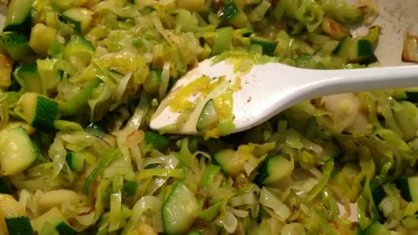 Daun bawang cincang dan rebusan zucchini di panci — Stok Video