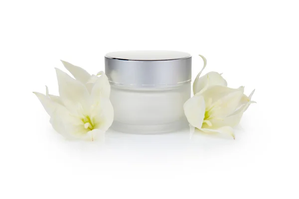 Jar with the cosmetic cream and flowers — Stock Photo, Image