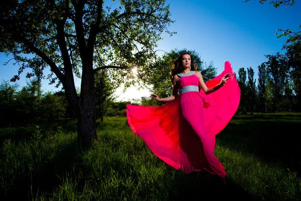 Frau in einem langen rosa Kleid — Stockfoto