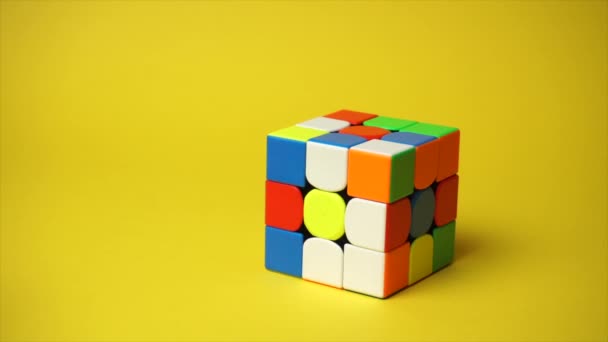 Rubiks kubus op gele achtergrond — Stockvideo
