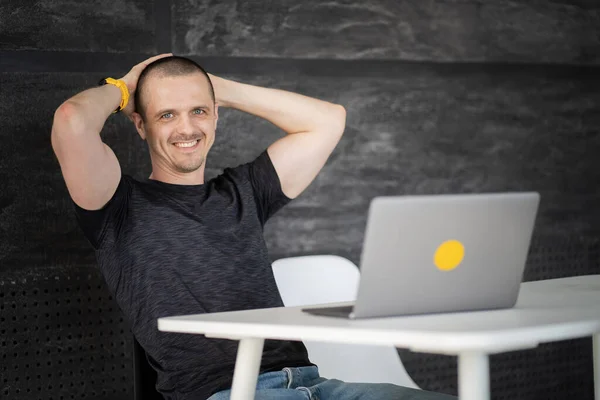 Happy man working on laptop in library or coworking office space — Zdjęcie stockowe