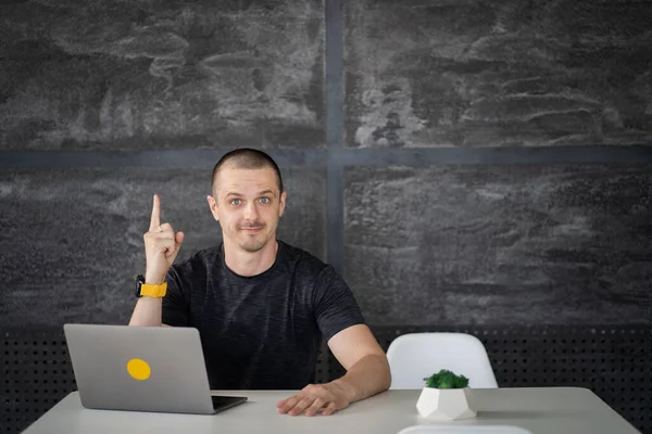 Happy man working on laptop in library or coworking office space — Zdjęcie stockowe