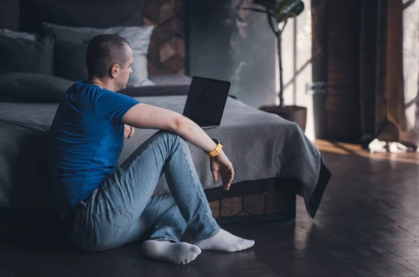 Adult man in blue t-shirt working on laptop — Foto Stock