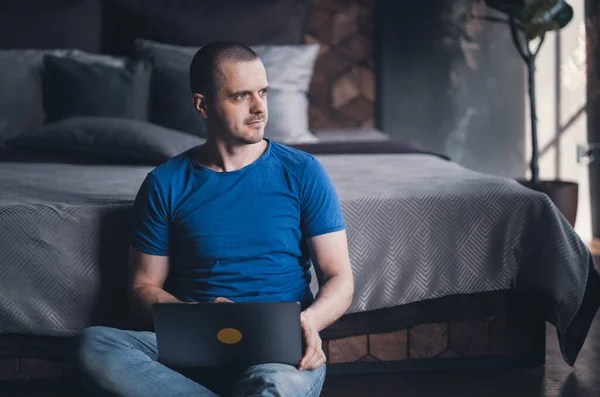 Homme adulte en t-shirt bleu travaillant sur ordinateur portable — Photo