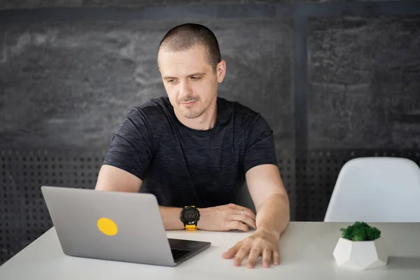 Happy man working on laptop in library or coworking office space — Photo