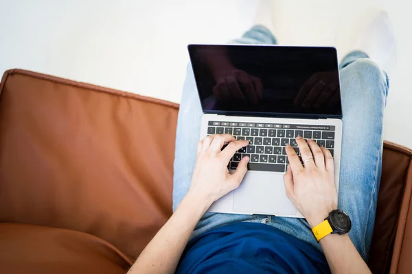 Man freelancer working on laptop sitting in chair Images De Stock Libres De Droits