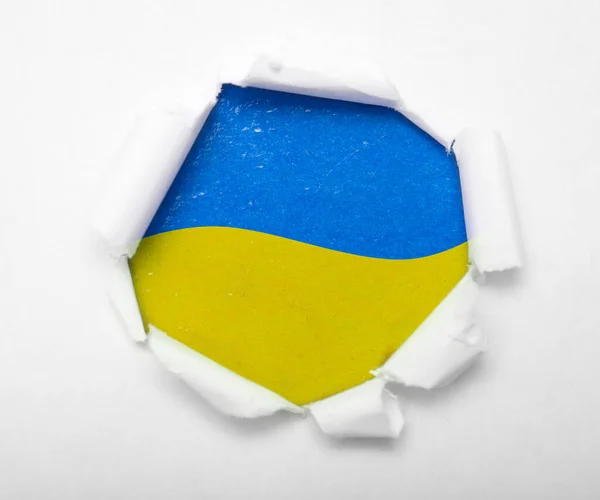 紙の中の丸い穴の中にウクライナの青と黄色の旗 ストックフォト