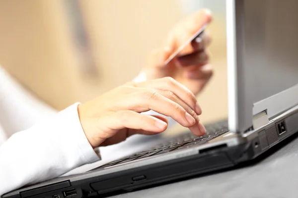 Hands holding credit card and laptop. Shallow DOF — Stock Photo, Image