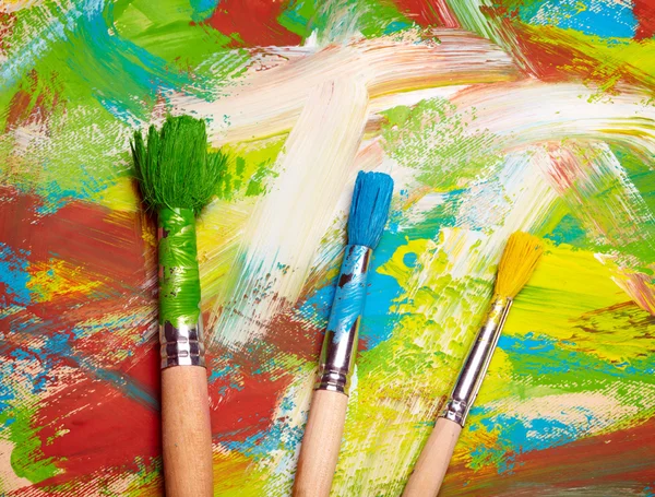 Paintbrushes on abstract grange background — Stock Photo, Image