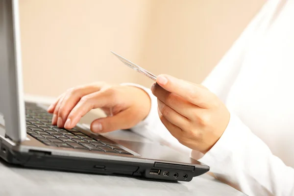 Mãos segurando cartão de crédito e laptop . — Fotografia de Stock