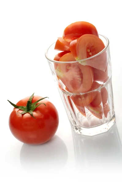 Tomato and slices in glass — Stock Photo, Image