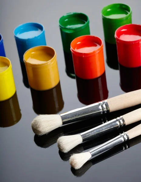 Paint buckets with paintbrush over dark background — Stock Photo, Image