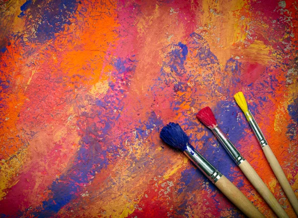 Paintbrushes on abstract grange background — Stock Photo, Image