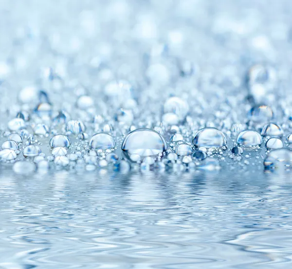 Blaue Tröpfchen spiegeln sich im Wasser — Stockfoto