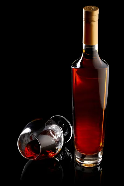Láhve a sklenice koňaku černém pozadí — Stock fotografie