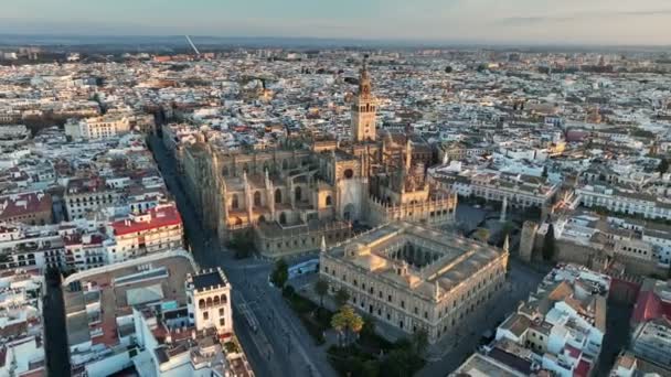 Voando sobre a catedral gótica na cidade velha de Sevilha com a famosa torre do sino Giralda. Drone aéreo de Sevilha, capital da região de Spains Andaluzia. Nascer do sol em Sevilha — Vídeo de Stock
