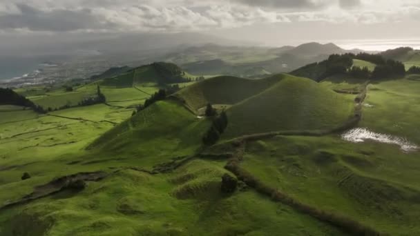 Vista aérea desde Miradouro do Pico do Carvao, Ponta Delgada, isla de San Miguel. Magnífica naturaleza de las Azores con prados verdes, cráteres y el océano — Vídeos de Stock