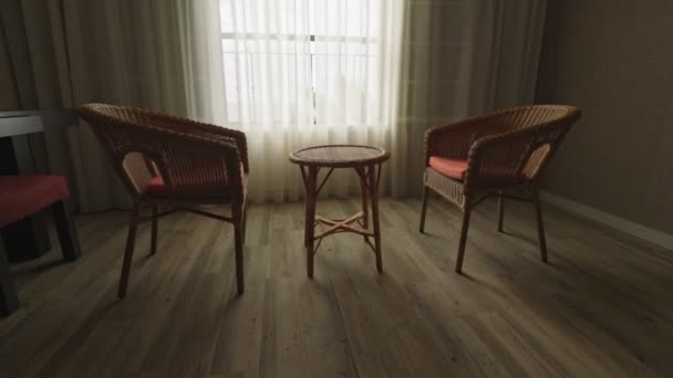 Dwa puste krzesła i stół przy oknie. Beztroska starość, pustka, samotność, rozstanie, koncepcja oddzielająca. Gimbal strzał, 4K — Wideo stockowe