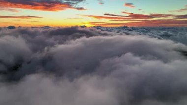 Yoğun bulutların üzerinde şafak vakti uçun. Bulutların üzerinde muhteşem bir gün doğumu. Kızıl gökyüzü ile harika bir sabah görüntüsü.