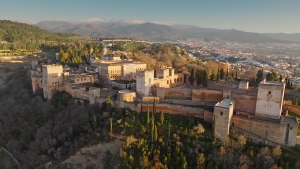 Gran vista al atardecer de la fortaleza árabe Alhambra en Granada. Vista aérea de la Alhambra con fondo de montañas nevadas. Andalucía, España — Vídeos de Stock