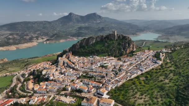 Vliegen over de oranje daken van de stad, fort op de berg en het uitzicht op de rivier in Zahara de la sierra. — Stockvideo