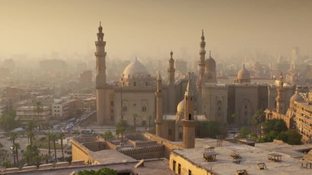 Zbliżenie z meczetu sułtana Hassana, Kair, Egipt o zachodzie słońca. Miasto Kair w jasnej mgle w promieniach zachodzącego słońca — Wideo stockowe