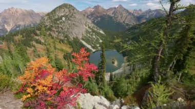 Kuzey Cascades Ulusal Parkı 'ndaki dağlar ve göl, ABD. Dağlarda sonbahar. Amerika Birleşik Devletleri 'nin doğası, ani atış. Kudretli dağ zirvelerinin arka planında kırmızı-sarı yapraklar