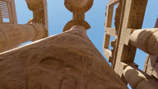 Camera moves between majestic columns with ancient Egyptian drawings. Gimbal high quality shot. Karnak Temple in Luxor, Egypt — Vídeos de Stock