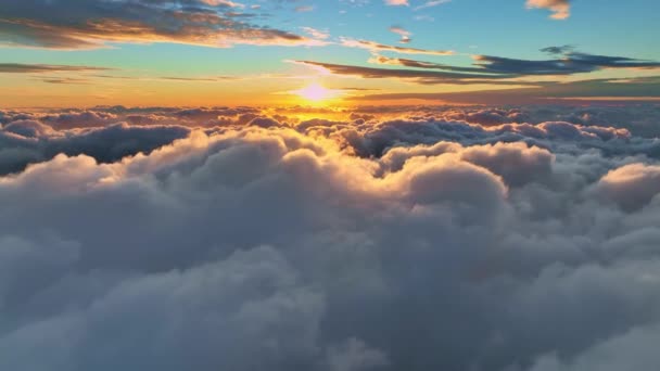 Camera stijgt boven wolken, gouden zonsopgang. Vliegen boven de wolken verlicht door de ochtendzon. Epische zonsopgang aan de hemel. Luchtfoto — Stockvideo