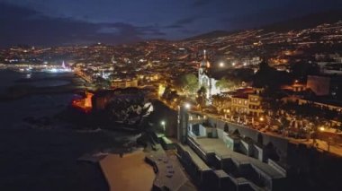 Funchal şehrinin havadan görünüşü, Madeira, Portekiz. Akşamları kıyı şeridinde uçarken Funchal, mavi günbatımı gökyüzü