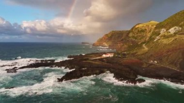 Portekiz, Azores 'teki Sao Miguel Adası' ndaki Ponta da Ferraria Burnu 'nun batı manzarası. Kahverengi kayalar, Atlantik okyanusu ve gökkuşağı