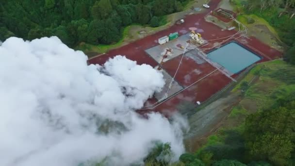 El vapor proviene de la chimenea de la planta de energía geotérmica. Producción de energía geotérmica en la isla de Sao Miguel, Azores, Portugal. Disparo aéreo, 4K — Vídeos de Stock