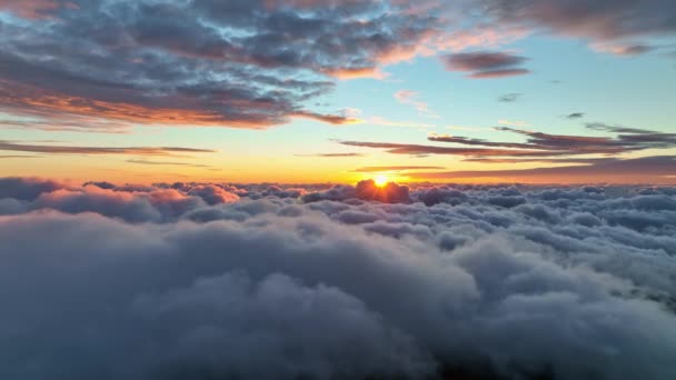 Güneş bulutların üzerinde sabahın erken saatlerinde bir bulutun arkasından çıkar. Sabah güneşiyle aydınlanan bulutların üzerinde uçuyor. Gökyüzünde destansı gün doğumu — Stok video