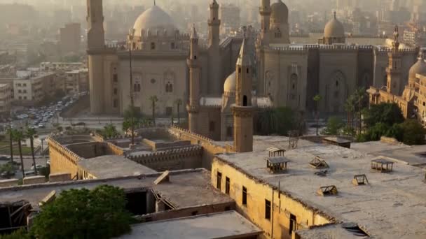 日没時にエジプトのカイロ、スルタンハサンのモスクの傾きのショット。カイロの街の最高の景色の一つ-車で家、モスク、道路. — ストック動画