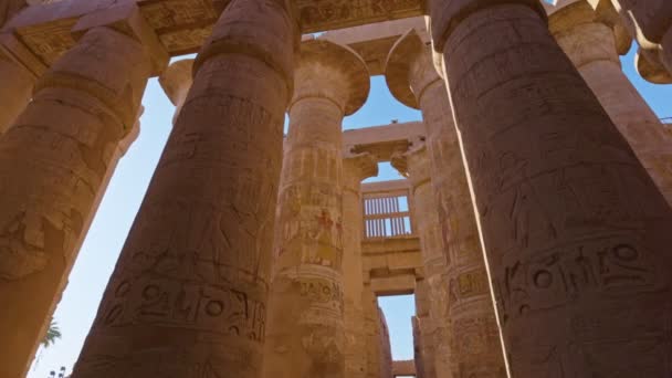 Karnak Temple in Luxor, Egypt. Majestic columns with ancient Egyptian drawings. Camera moves between columns with ancient Egyptian drawings — ストック動画