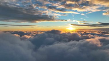 Aerial hyperlapse of magnificent sunset above the clouds. Flying over flying over thick clouds in the rays of the setting sun.